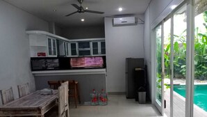 Cocina compacta con comedor, ventilador de techo y vista a una piscina.