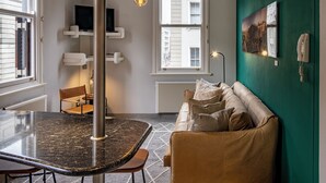 Een moderne woonkamer met een ronde tafel, een bank en een groene accentmuur.