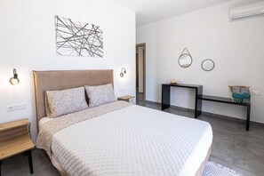 Una camera da letto moderna con un letto grande, comodini, una scrivania e uno specchio a parete.