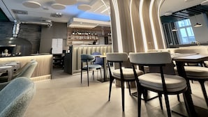 Un interior moderno con una zona de bar, asientos y un techo con diseño.