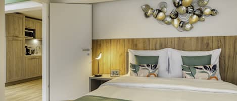 A bedroom with a wooden headboard, a bed with green bedding, and a wall-mounted decorative piece.