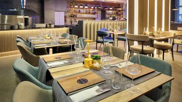 A restaurant with multiple tables set for dining, each with a menu, wine glass, and cutlery.