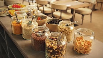 Ein Buffet mit verschiedenen Speisen in Glasbehältern und Schüsseln.