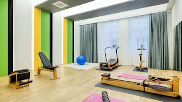 A fitness room with exercise equipment, a blue exercise ball, and a rowing machine.