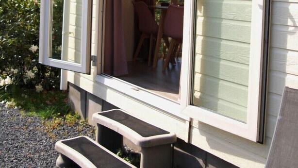 A single-story house with a sliding glass door leading to an outdoor patio area.