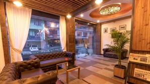Un hall d’hôtel moderne avec un canapé en cuir, une table basse et une plante en pot.