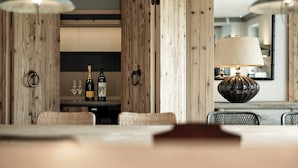 A wooden interior with a dining table, two wine glasses, and two bottles of wine. - Chalet Cecilia by MYALPS (Soelden)