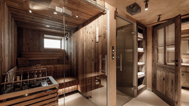 A modern interior with wooden paneling, a sauna, and a glass-enclosed shower area. - Chalet Cecilia by MYALPS (Soelden)