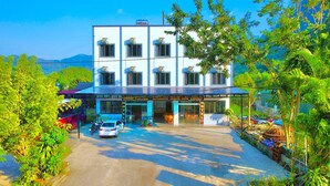 Ein modernes Hotel mit zweigeschossiger Bauweise, mehreren Klimaanlagen und einem überdachten Eingang.