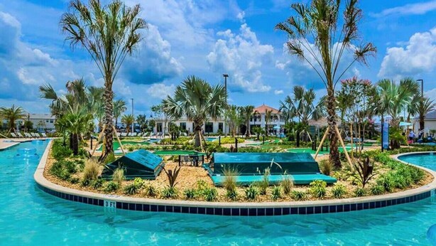 A swimming pool with palm trees and lounge chairs.