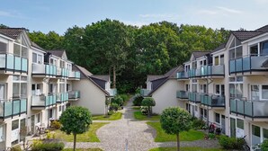 A modern apartment complex with a central courtyard, balconies, and a well-maintained garden. - Appartementanlage Eldena Wohnung Nr. 10 (Mönchgut OT Lobbe)
