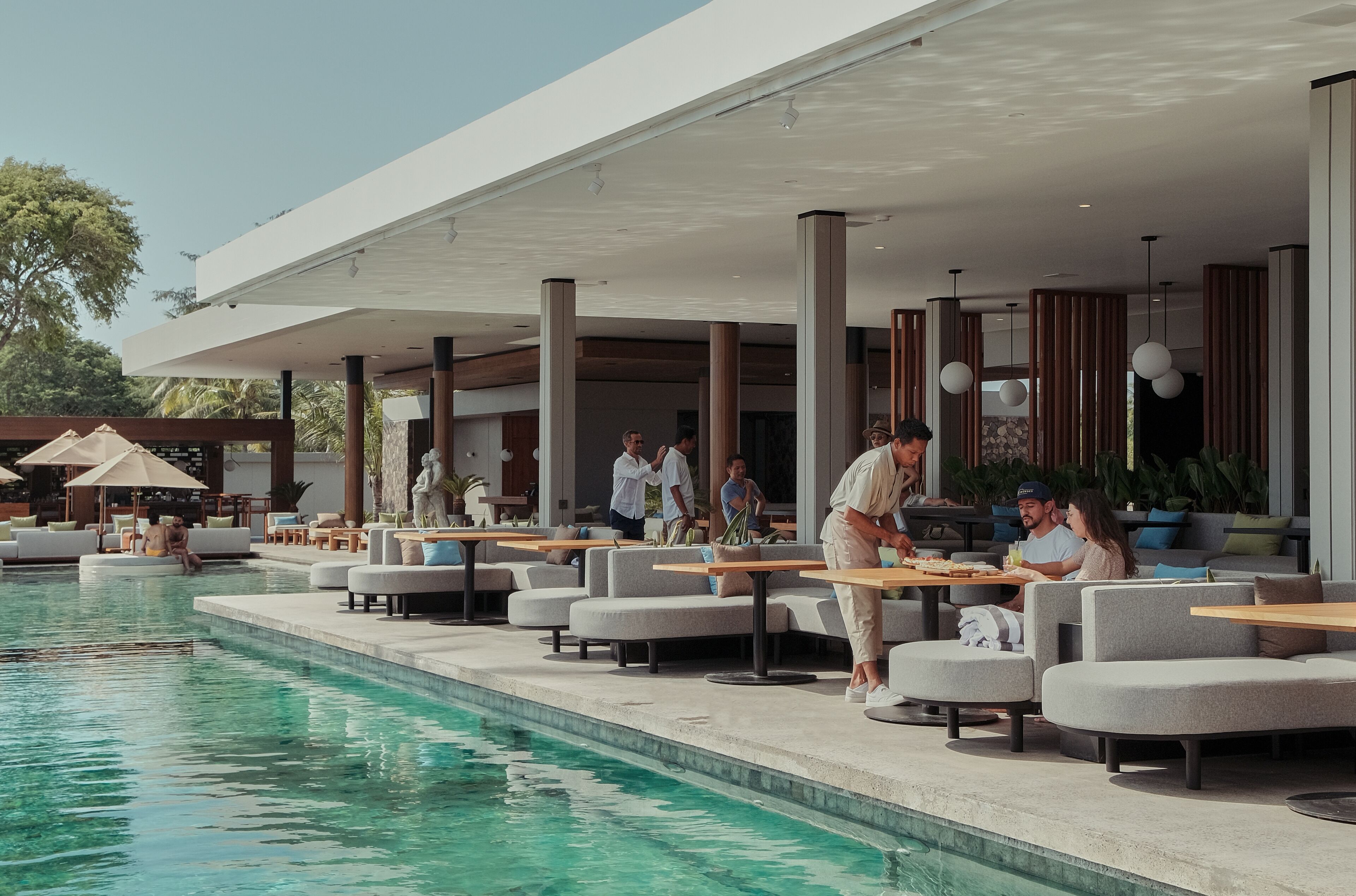 Un espace aménagé au bord de la piscine, avec des sièges et une table à l’extérieur, ainsi qu’une piscine.