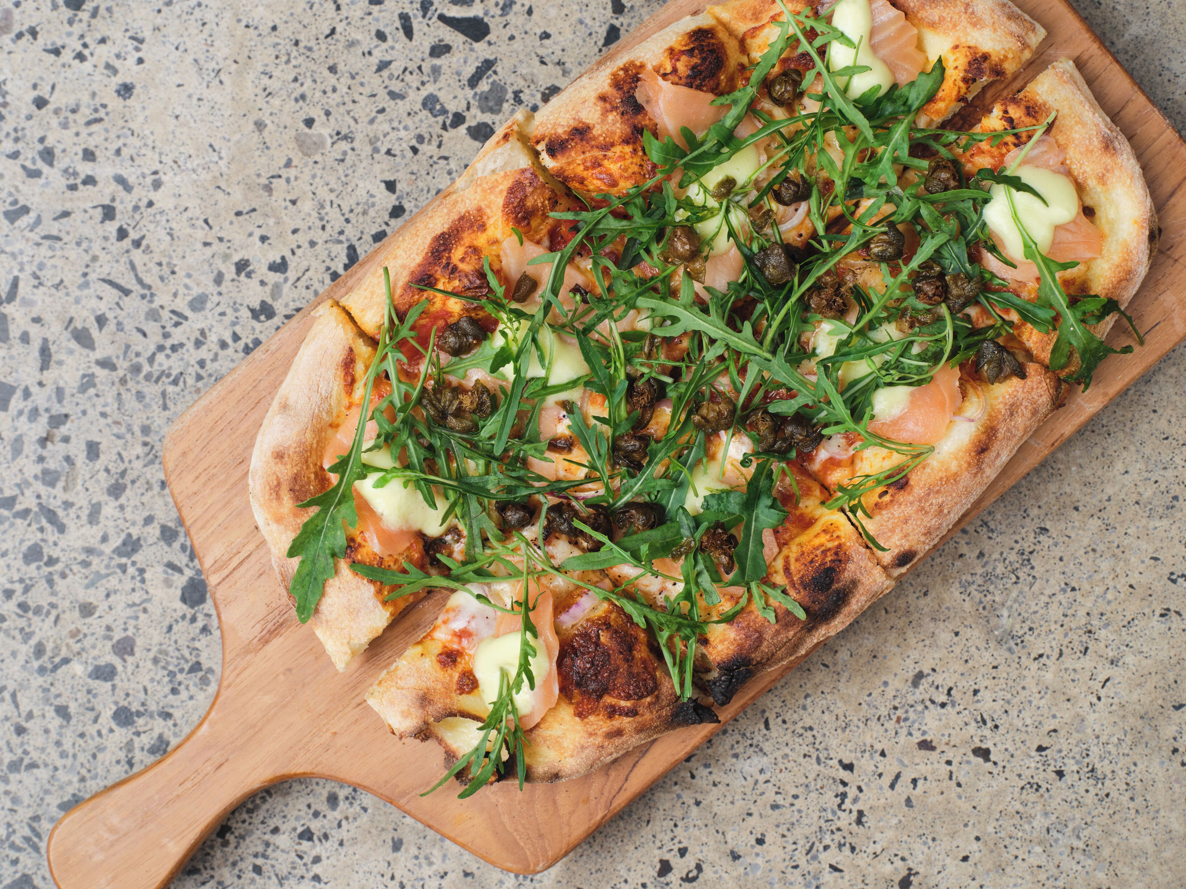 A pizza on a wooden board.