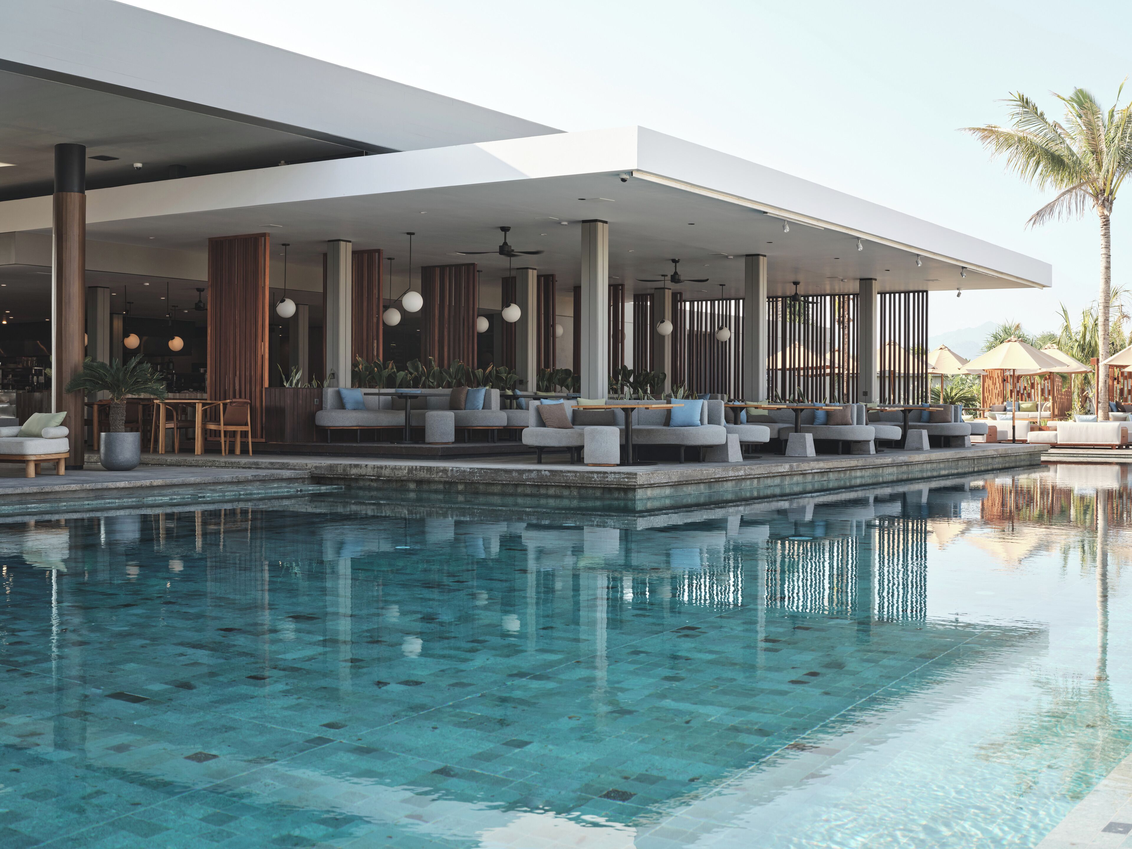 A modern poolside area with seating and a view of the pool.