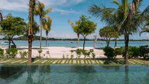 A clear view of a swimming pool with a tropical beach and palm trees in the background. - BASK GILI MENO (Gili Meno)