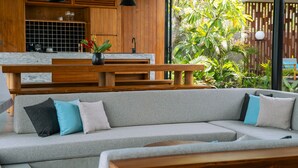 Una cocina moderna con armarios de madera, encimera de mármol y un banco empotrado.