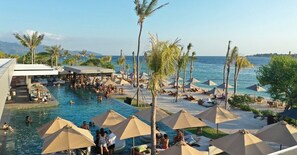 A pool area with umbrellas, palm trees, and a view of the sea. - BASK GILI MENO (Gili Meno)