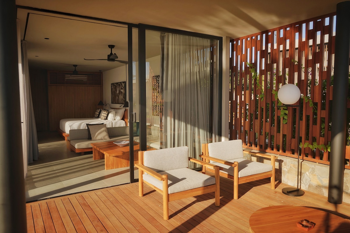 A modern room with a bed, a sofa, and a wooden floor.