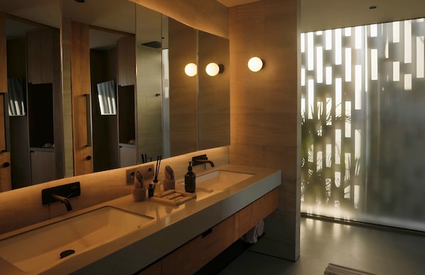 A modern bathroom with a large mirror, two sinks, and a frosted glass partition. - BASK GILI MENO (Gili Meno)
