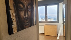 A room with a large window, a wooden floor, and a wall-mounted artwork. - Appartement Rénové Avec une Magnifique vue (Font-Romeu-Odeillo-Via)