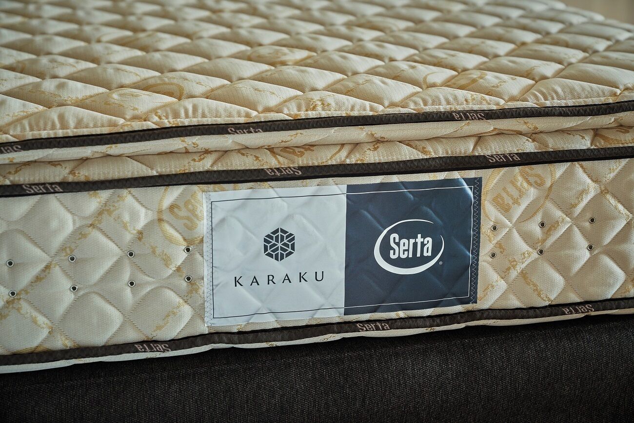 Un matelas à motifs matelassés et portant une étiquette indiquant les marques « KARAKU » et « Serta ».