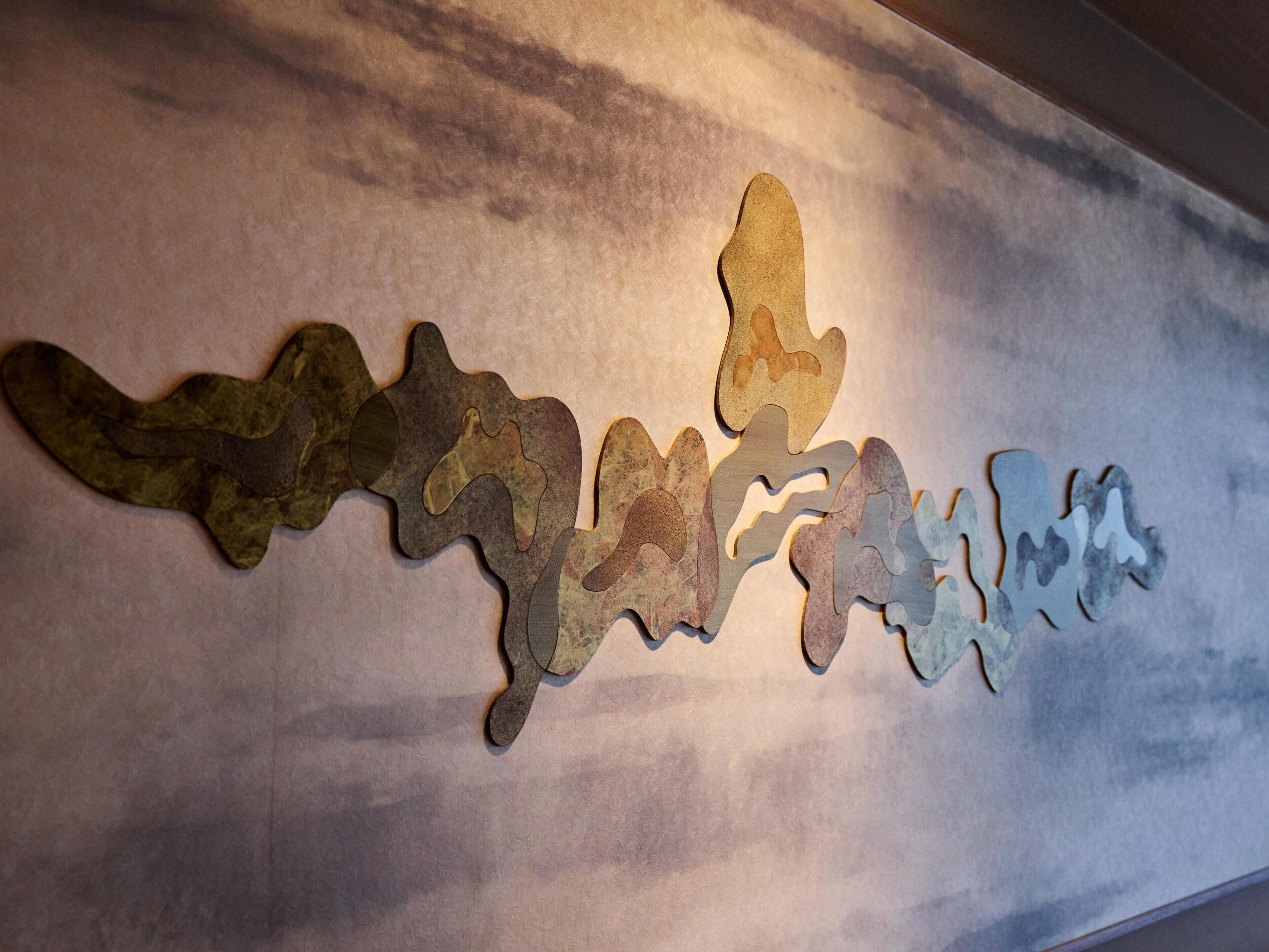 A wall with abstract metal art pieces.