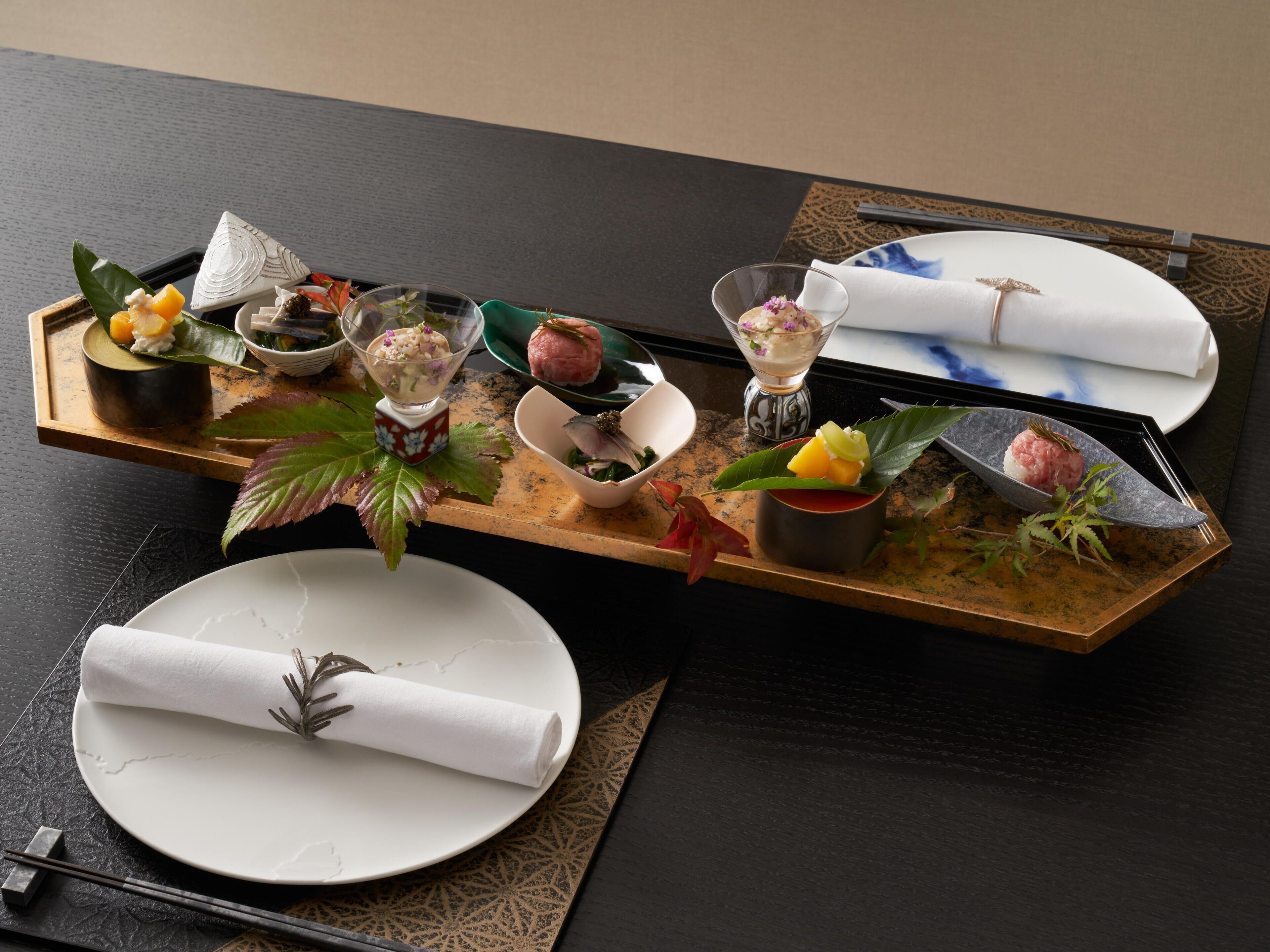 A dining table with a variety of dishes and a neatly rolled white napkin.