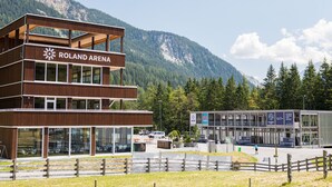 A modern building with the sign "Roland Arena" indicating it is a sports venue. - Nordic Hostel (Lantsch-Lenz)