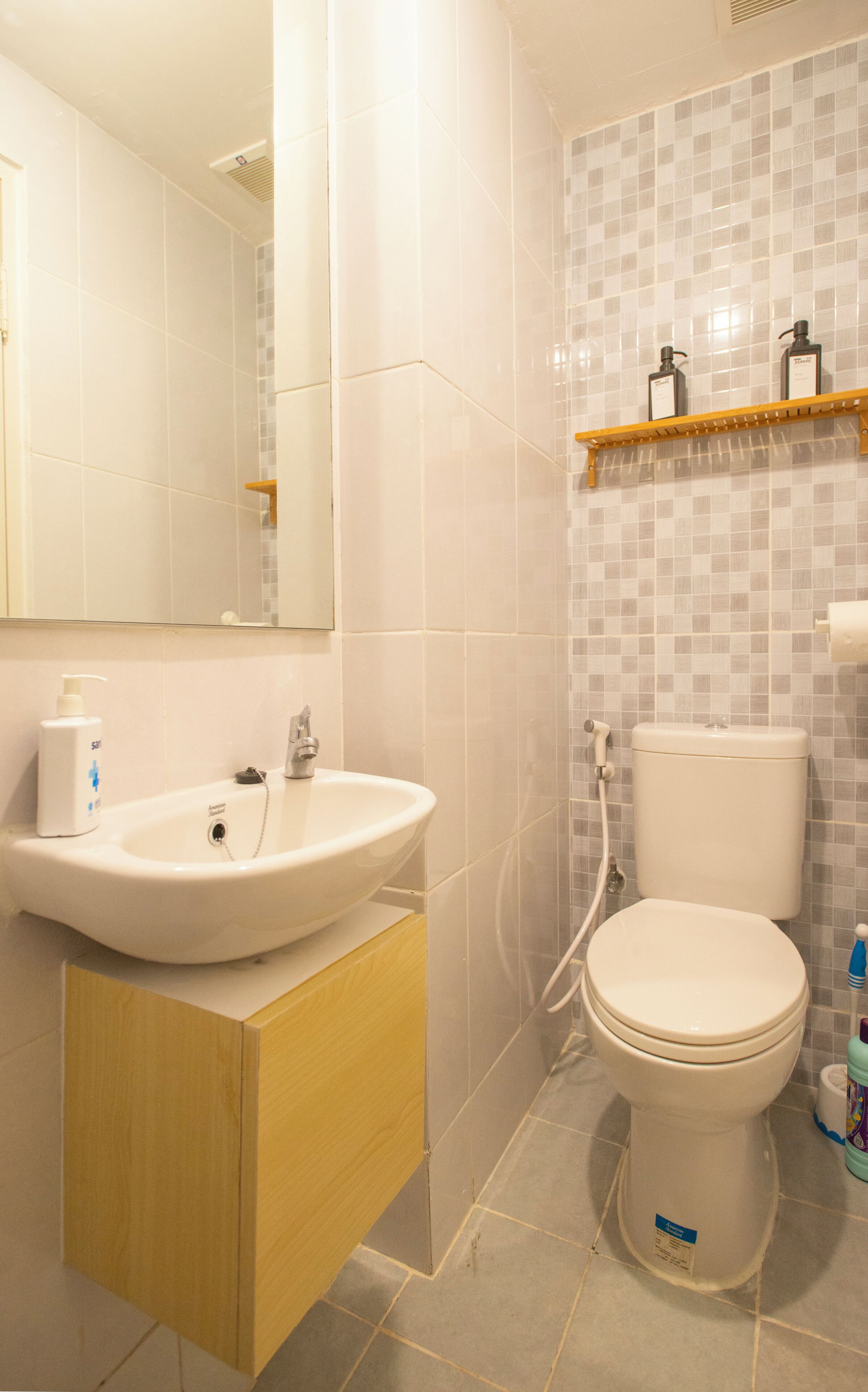 Un baño con un lavamanos blanco, un inodoro y un espejo.