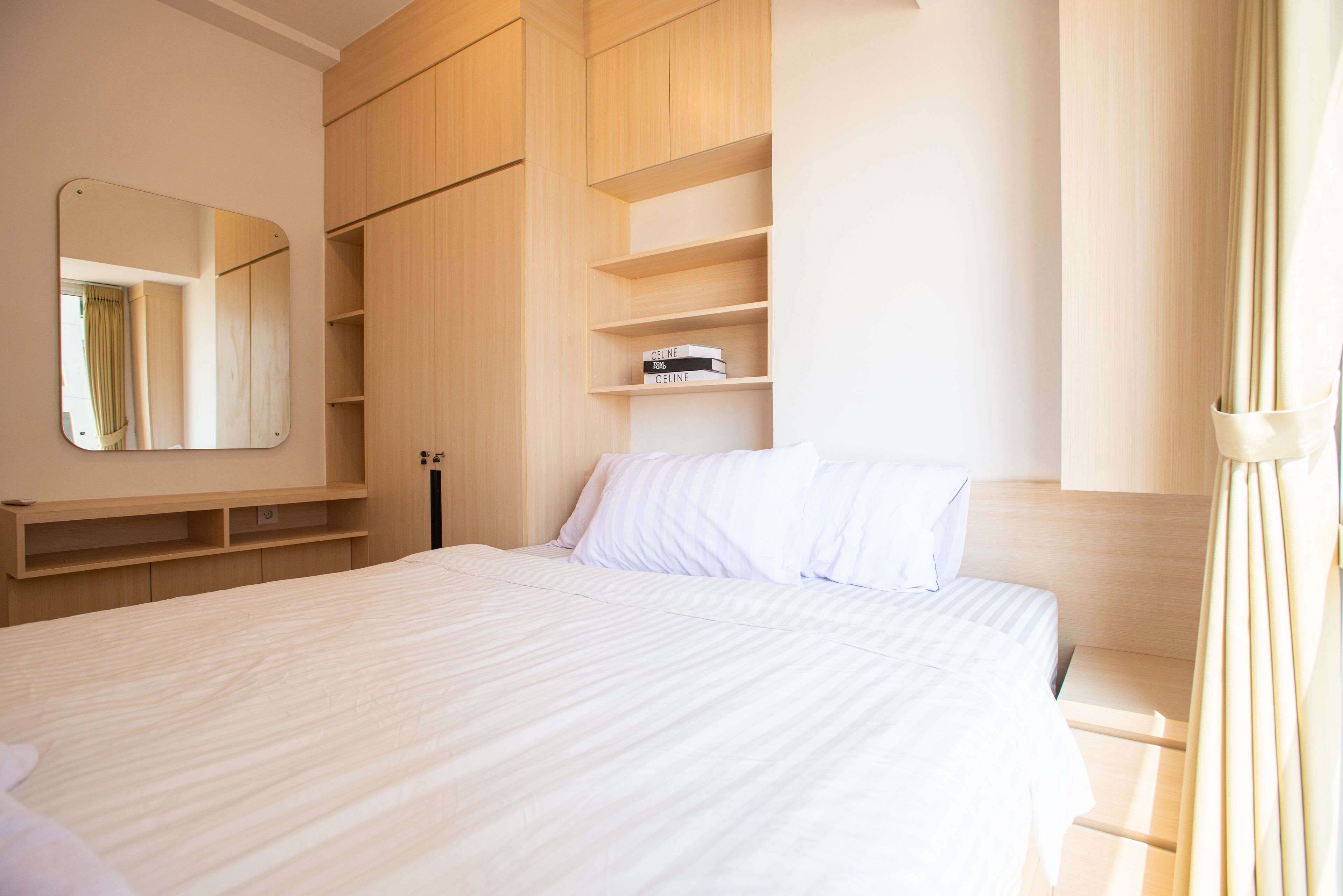 A bedroom with a large bed, a wardrobe, and a mirror.