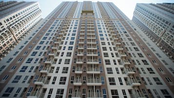 Um edifício residencial alto com várias varandas e fachada uniforme.