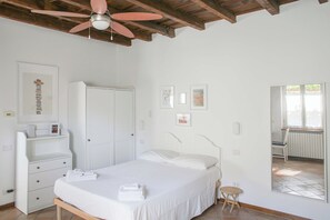 Ein Schlafzimmer mit einem Bett, einem Kleiderschrank, einem kleinen Tisch und einem Stuhl.