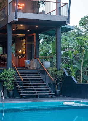A two-story building with a pool, outdoor seating, and a staircase leading to the upper level. - Kurokawa Kalutara (Wadduwa)