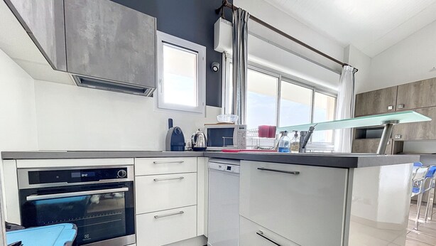 A compact kitchen with a built-in oven, a dishwasher, and a window above the sink. - Duplex T4 avec piscine, 6 couchages, garage, proche plage à Argelès-sur-Mer (Argelès-sur-Mer)