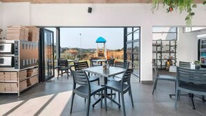 An open-plan kitchen with a view of a blue-roofed structure outside.