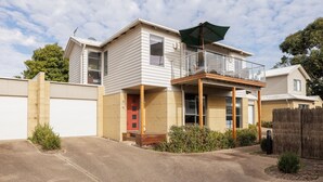 A two-story house with a balcony, a garage, and a small front yard.