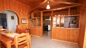 A wooden interior with a dining area, kitchen, and a hallway. - Seaside serenity apartment (Ermionida)