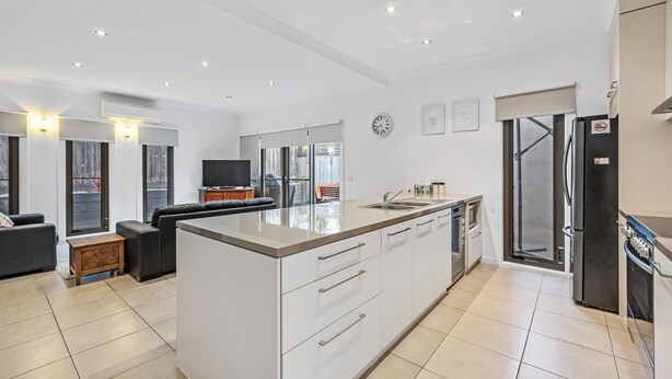 A modern kitchen with a central island, white cabinetry, and a large window. - Cowes Central Getaway (Cowes)