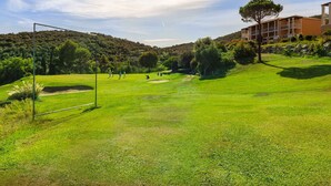 Un campo de golf con un edificio al fondo.