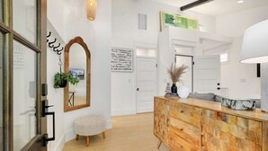 A modern interior with a wooden cabinet, a mirror, and a small round bench.