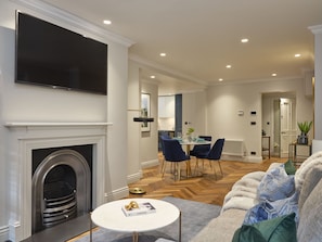 Cozy living space with a fireplace, flat-screen TV, and dining area for four.
