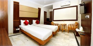 A hotel room with two beds, a TV, a desk, and a chair. - SET RESIDENCY (Kumbakonam)