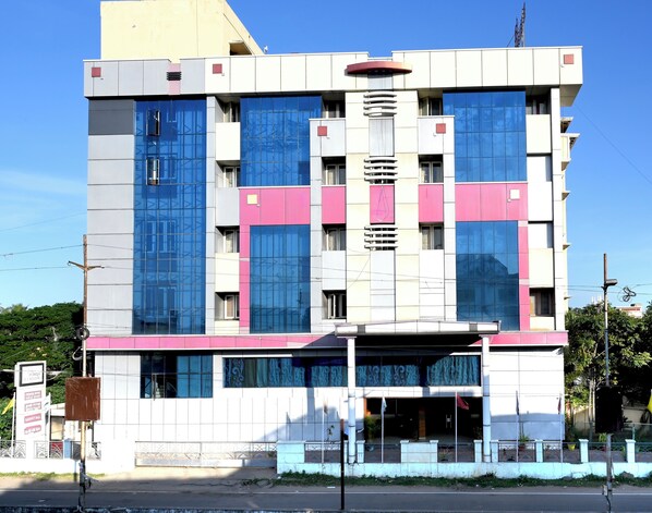 A multi-story building with a modern architectural design, featuring large windows and a mix of pink and white exterior panels. - SET RESIDENCY (Kumbakonam)