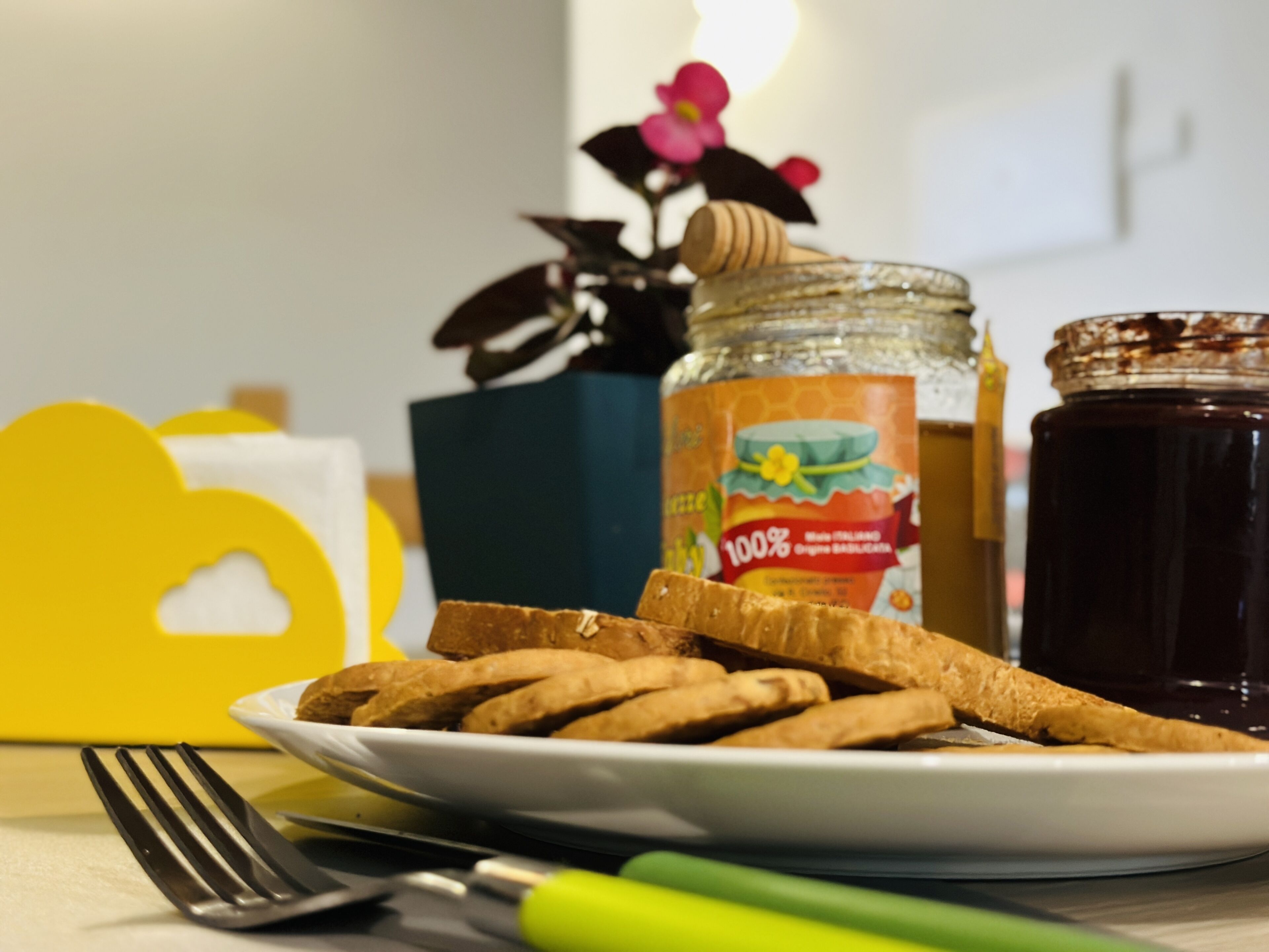 Een bord crackers en een pot honing op een tafel.