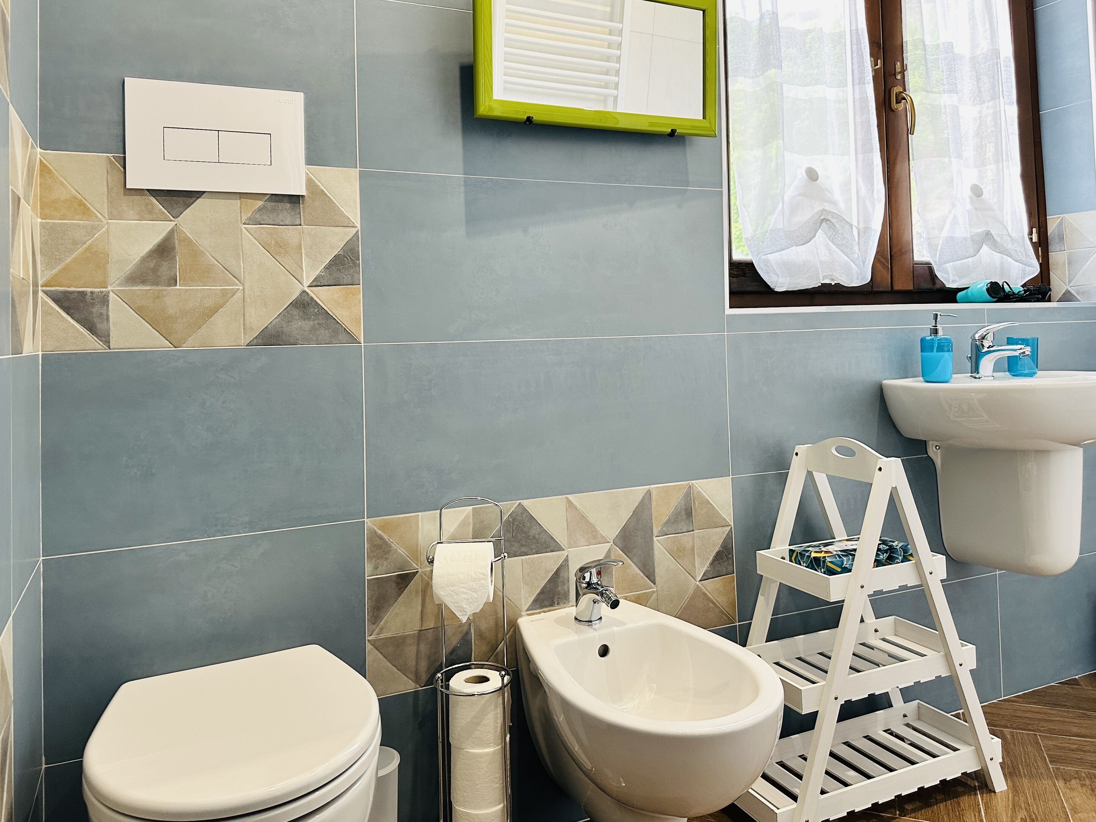 A modern bathroom with a toilet, bidet, and sink.