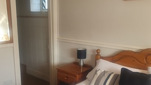 A bedroom with a bed, a nightstand, a lamp, and a framed picture on the wall. - The Shrubbery Hotel (Shepton Mallet)