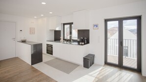Una cucina moderna con un'isola grande, forno integrato e una porta scorrevole in vetro su un balcone.