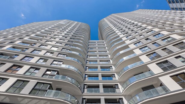 A modern high-rise building with curved balconies and large windows. - Stylish Studio in Wola | Air Conditioning and Balcony (Warszawa)