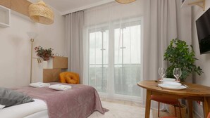 A modern hotel room with a bed, a small table with a plant, and a TV on the wall. - Stylish Studio in Wola | Air Conditioning and Balcony (Warszawa)