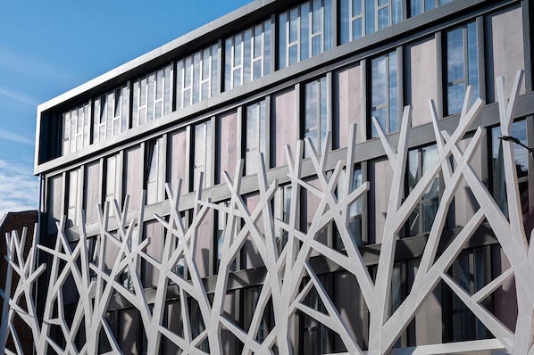 Un edificio moderno con fachada geométrica y grandes ventanales.